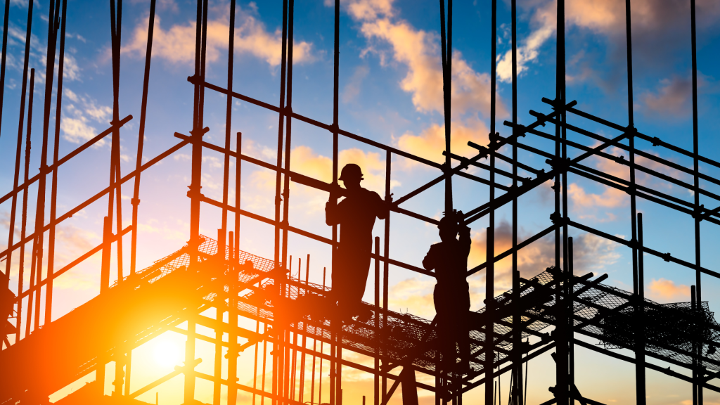 Construction workers on scaffolding at a building site.